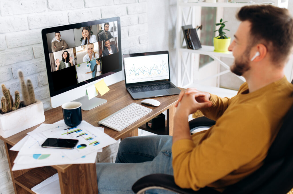 Man sitting at a desk in his home office while participating in a video conference.