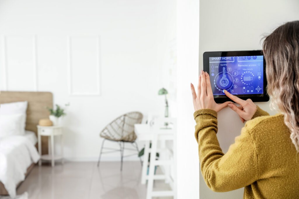 Woman adjusting the smart thermostat in her home.