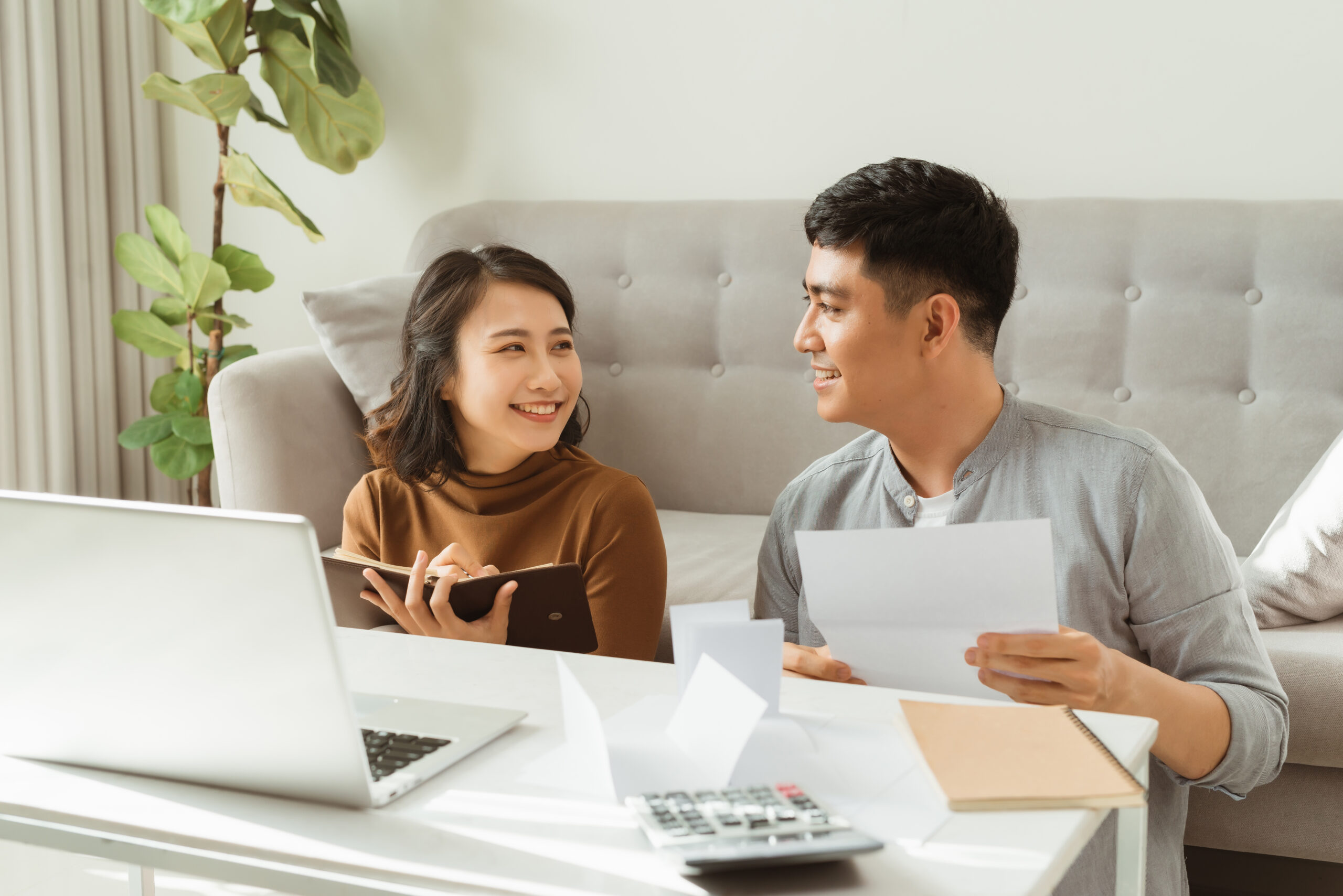 A couple sitting at their living room table reviewing their finances.