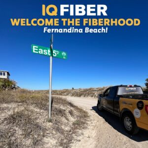 Graphic that says "Welcome to the Fiberhood Fernandina Beach!" with a picture of an IQ Fiber truck parked at the beach.
