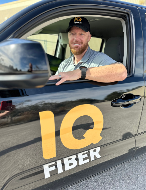 Construction coordinator sitting in an IQ Fiber vehicle.