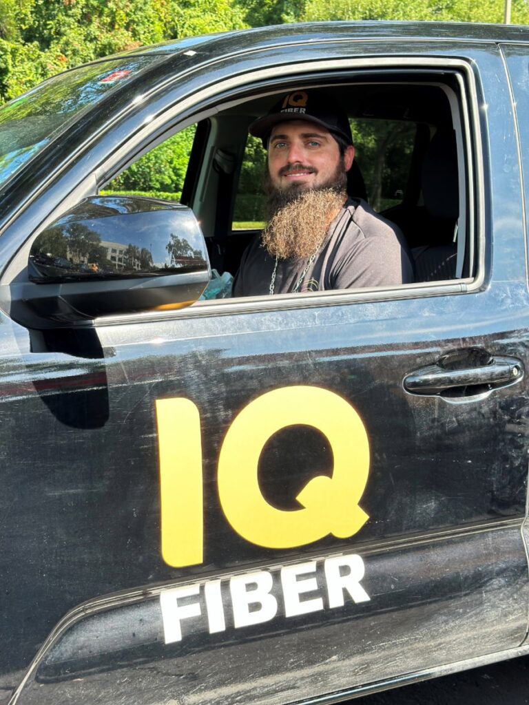 Construction coordinator sitting in an IQ Fiber truck.