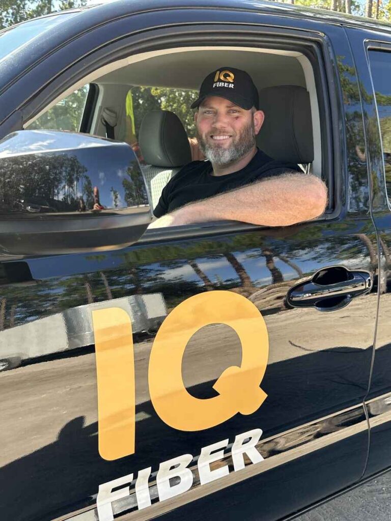 Construction coordinator sitting in an IQ Fiber vehicle.