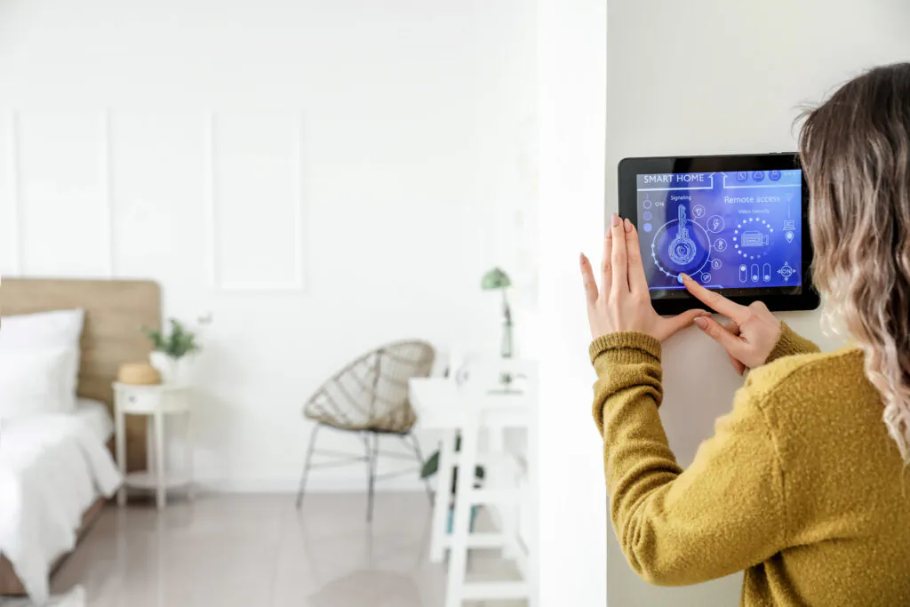 Woman adjusting the smart thermostat in her home.